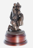 hand crafted 8" scale statuette of a Firefighter in the uniform of the 1970's era, wearing Siebe-Gorman breathing apparatus, protectively cradling a rescued infant. Handmade in bronze cold cast resin.