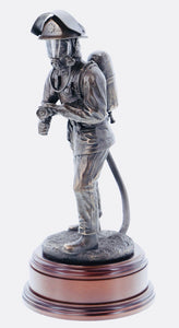hand crafted 11" scale statuette of a Firefighter undertaking firefighting duties with a charged branch. Handmade in bronze cold cast resin.